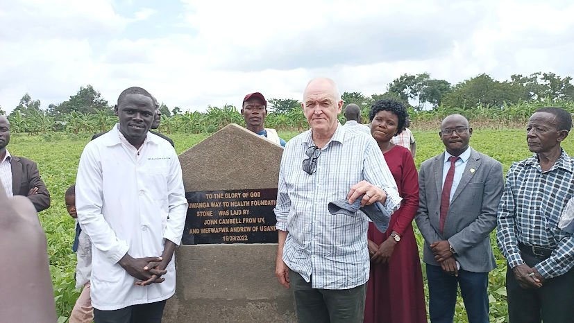 Wefwafwa Andrew and Dr. John Campbell with a plaque that reads: To the glory of God, Buwanga Way to Health Foundation, stone was laid by John Campbell from UK and Wefwafwa Andrew of Uganda 16/09/2022